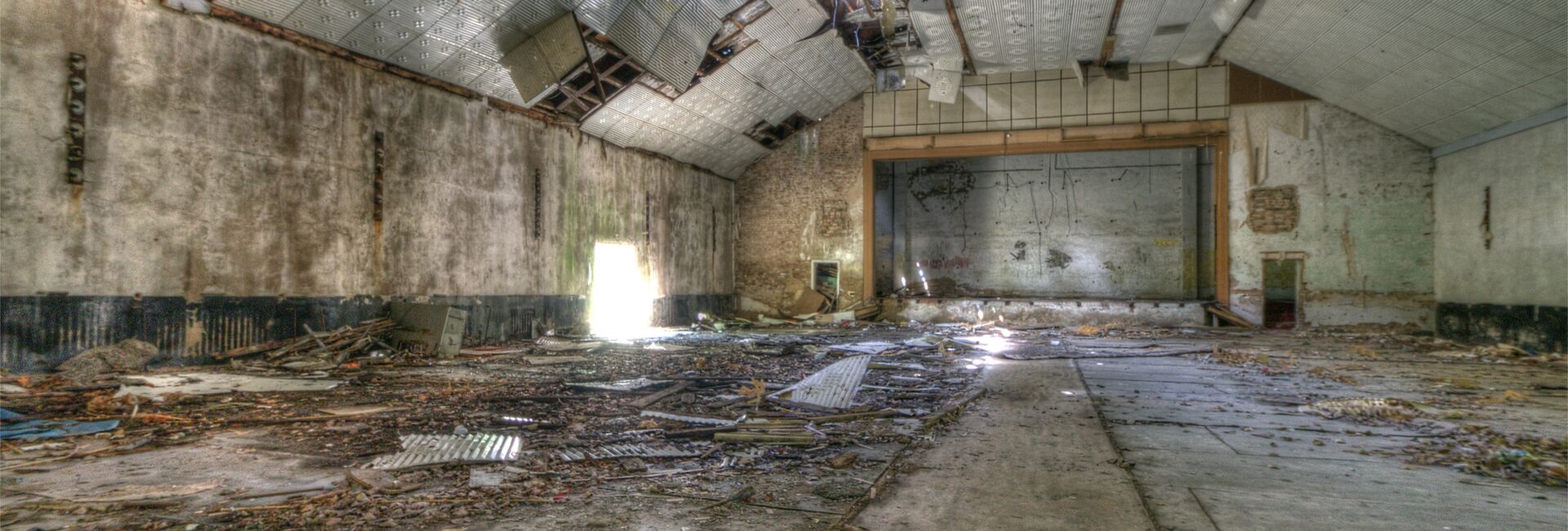 Einsturzgefährdete Halle mit kaputter Decke.