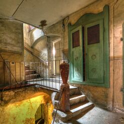 Verlassenes, schmutziges Treppenhaus mit Grün.